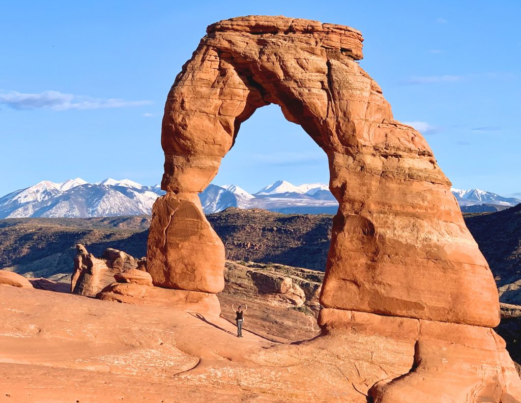 Explorer underneath delicate arch in arches national park