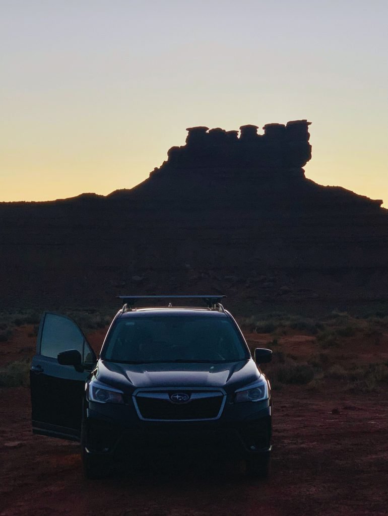 Subaru parked under striking cliffs in Arizona