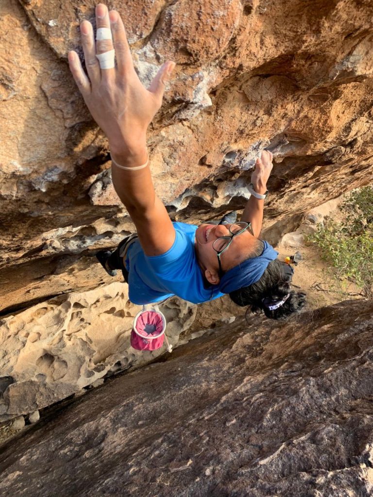 Lala climbing a boulder in Hueco Tanks