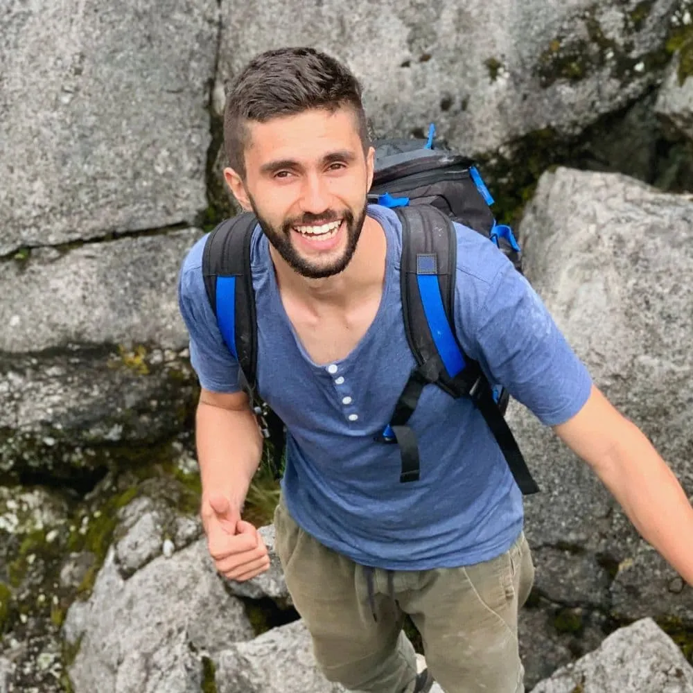 man in rocky outdoor setting smiling